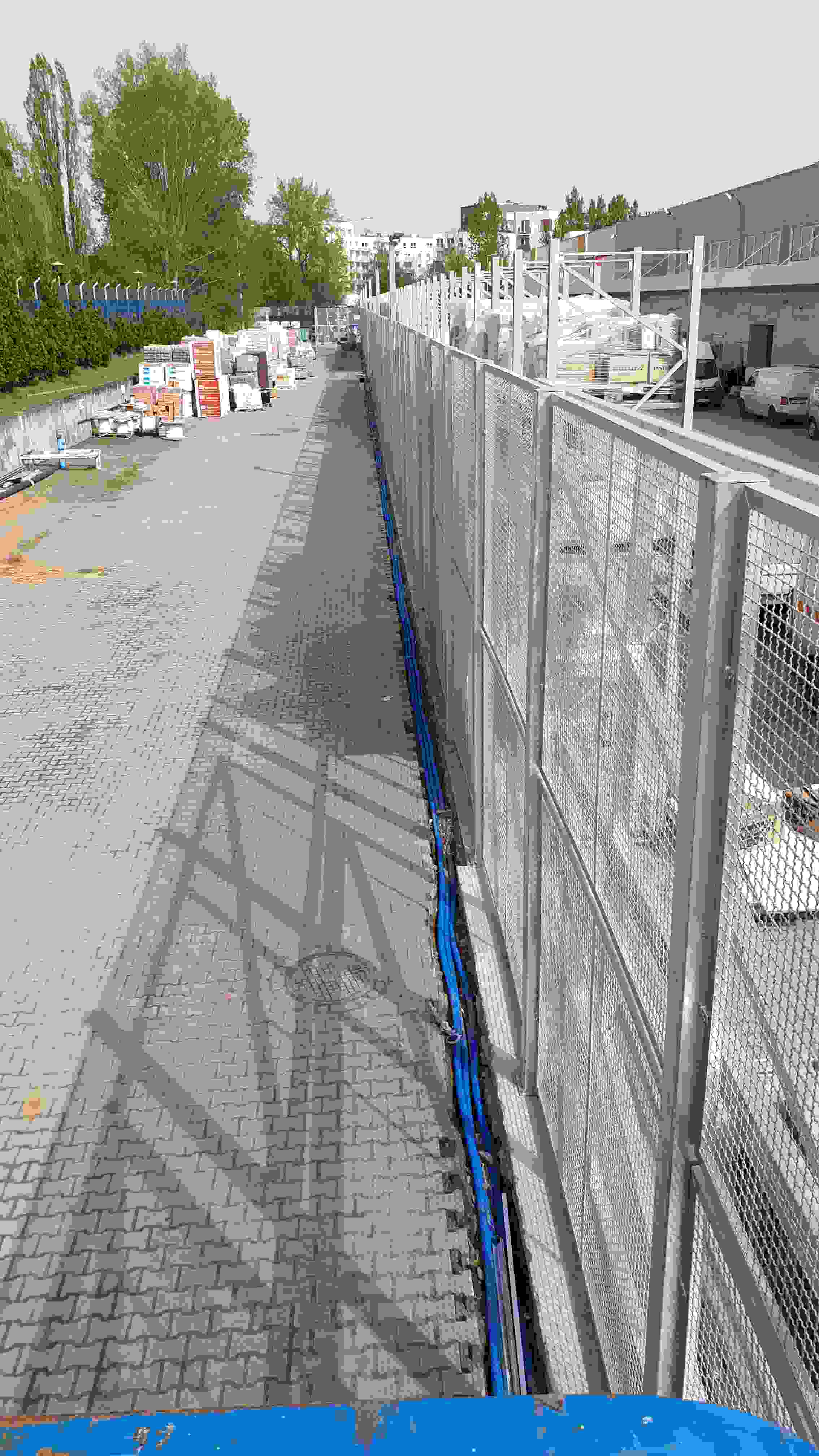Rury osłonowe z kablami wzdłuż ogrodzenia – instalacja zewnętrzna